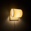 Wall-mounted lamp with a warm glow on a dark wall